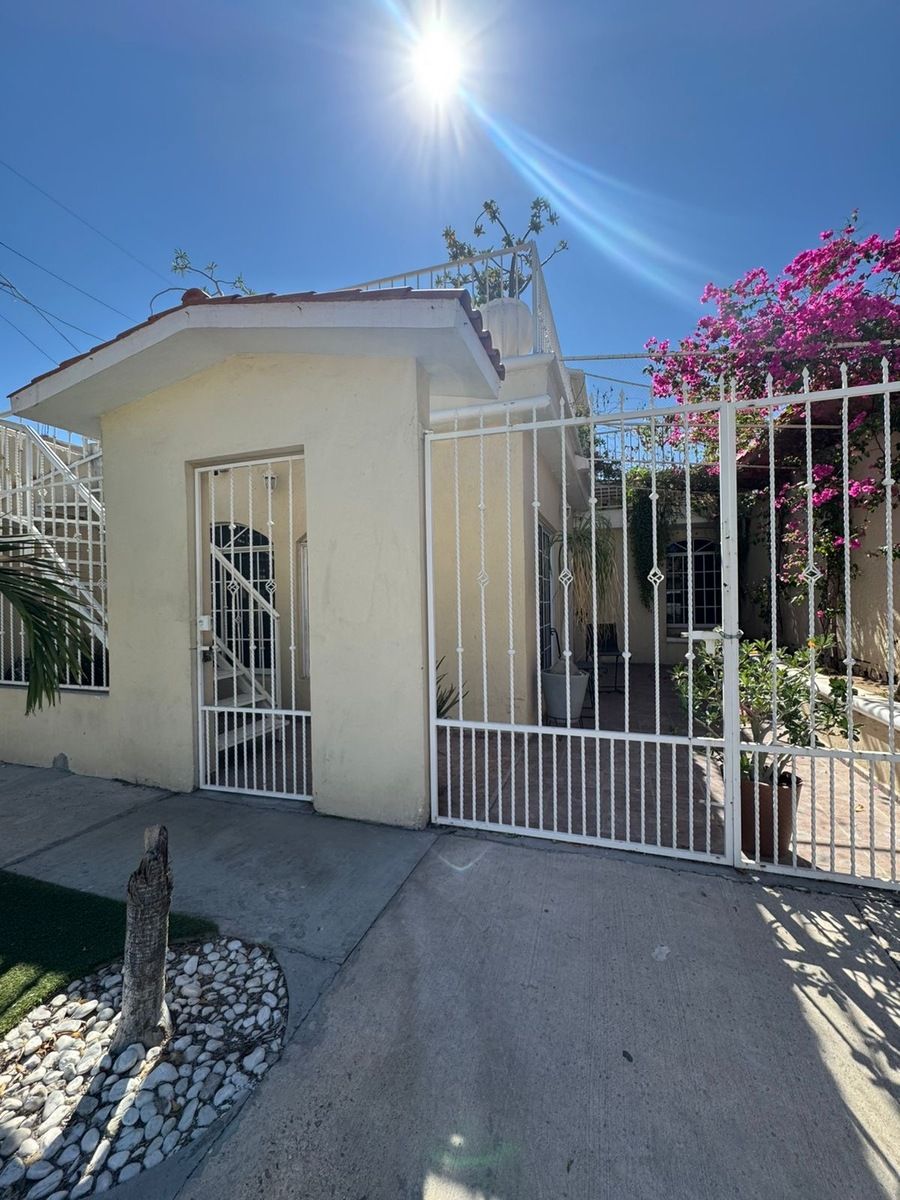 1 of 12: Fachada principal con plantas decorativas