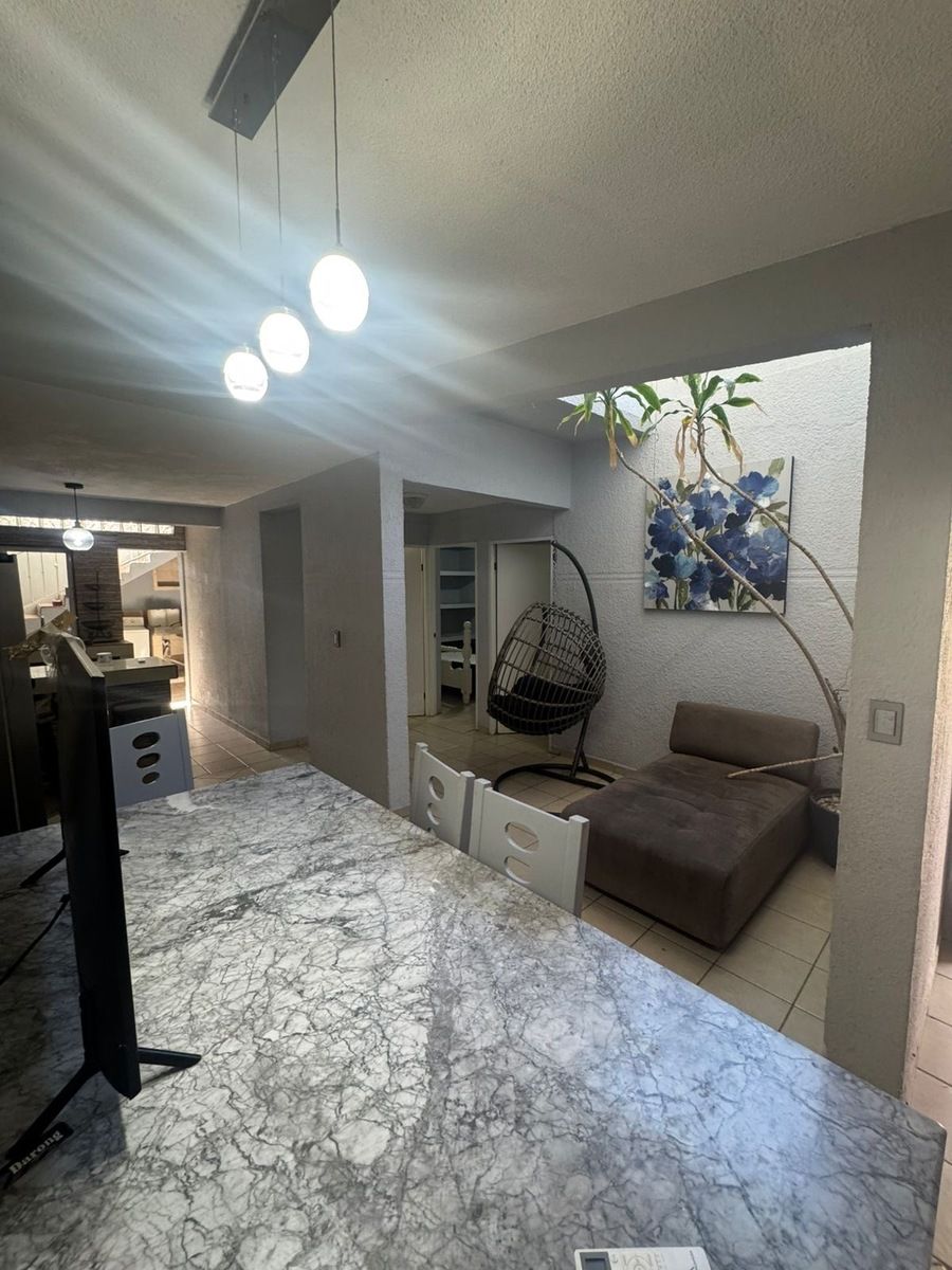 7 of 12: Espacio para descansar con sofá y coñumpuo