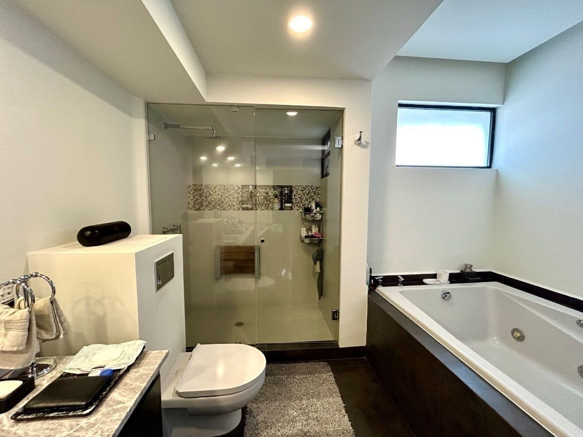 10 of 33: Baño de la recámara principal con ducha y tina