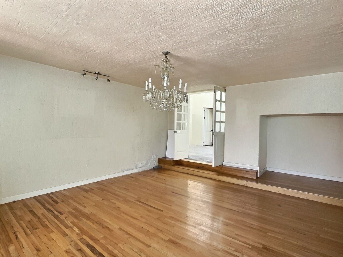 7 of 28: Amplia estancia con piso de madera y lámpara tipo candil