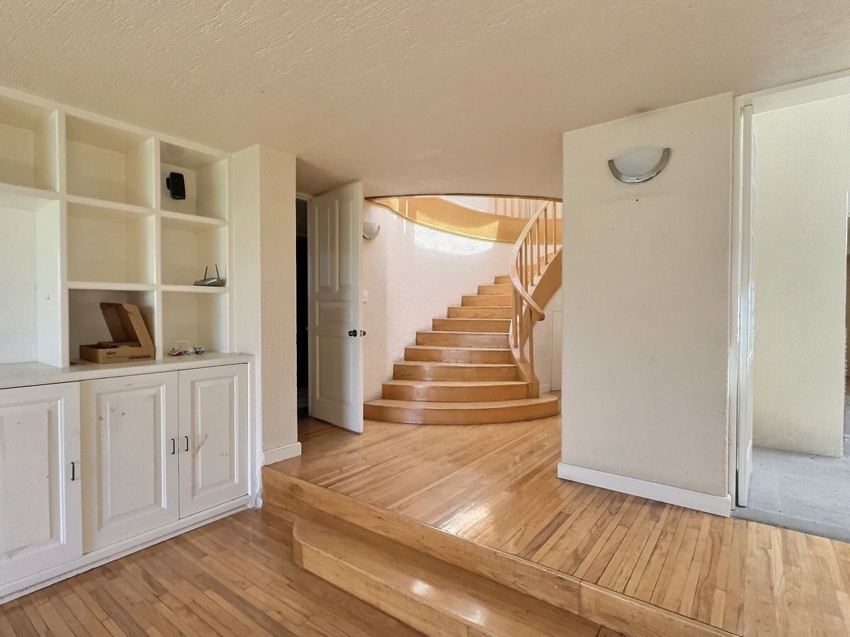 8 of 28: Vestíbulo con escalera y librero empotrado