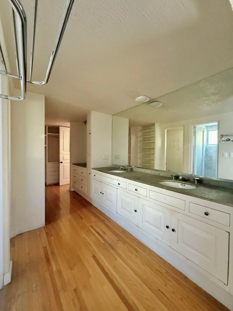 10 of 28: Amplio baño con dos lavamanos y cajoneras de almacenamiento