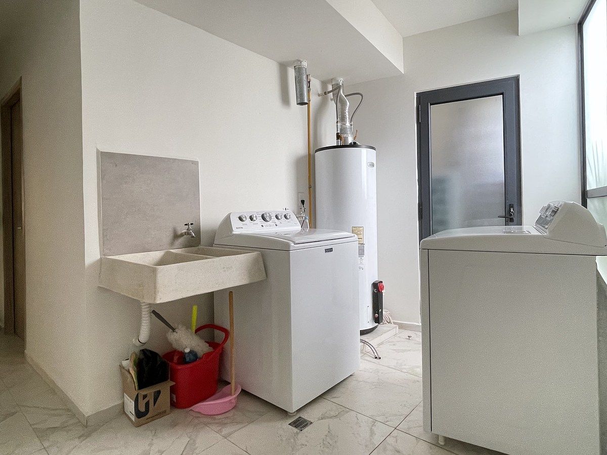 12 de 28: Área de servicio con lavadora, secadora y cuarto con baño