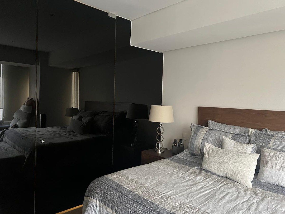 9 de 12: Entrada al baño principal en muro de cristal negro
