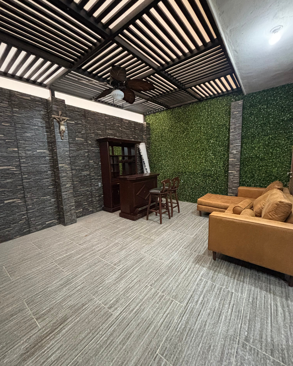 16 of 35: Patio social cerrado con abanico, sillón y área de bar