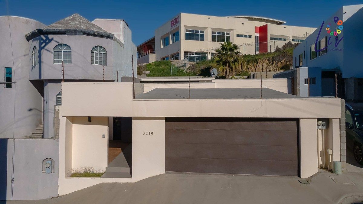 2 de 43: Frente de la casa con cochera eléctrica