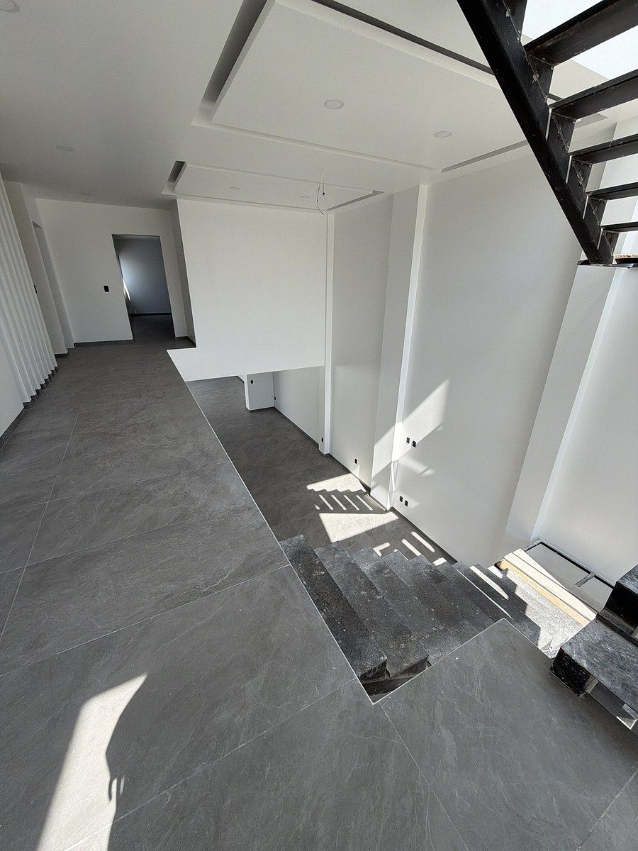 9 of 15: Pasillo superior con vista a la sala y escalera.