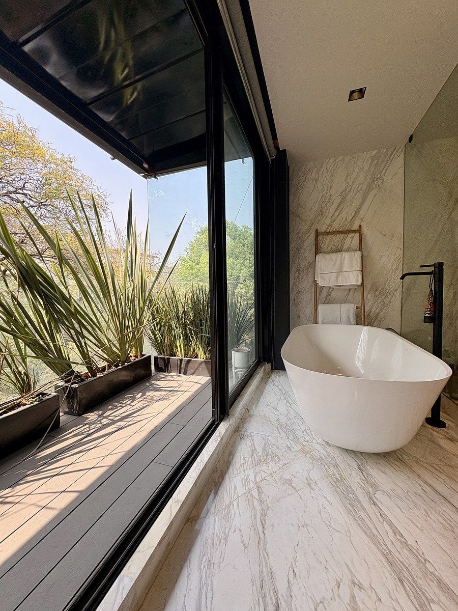 12 of 32: Baño principal con vista al exterior y acabados elegantes