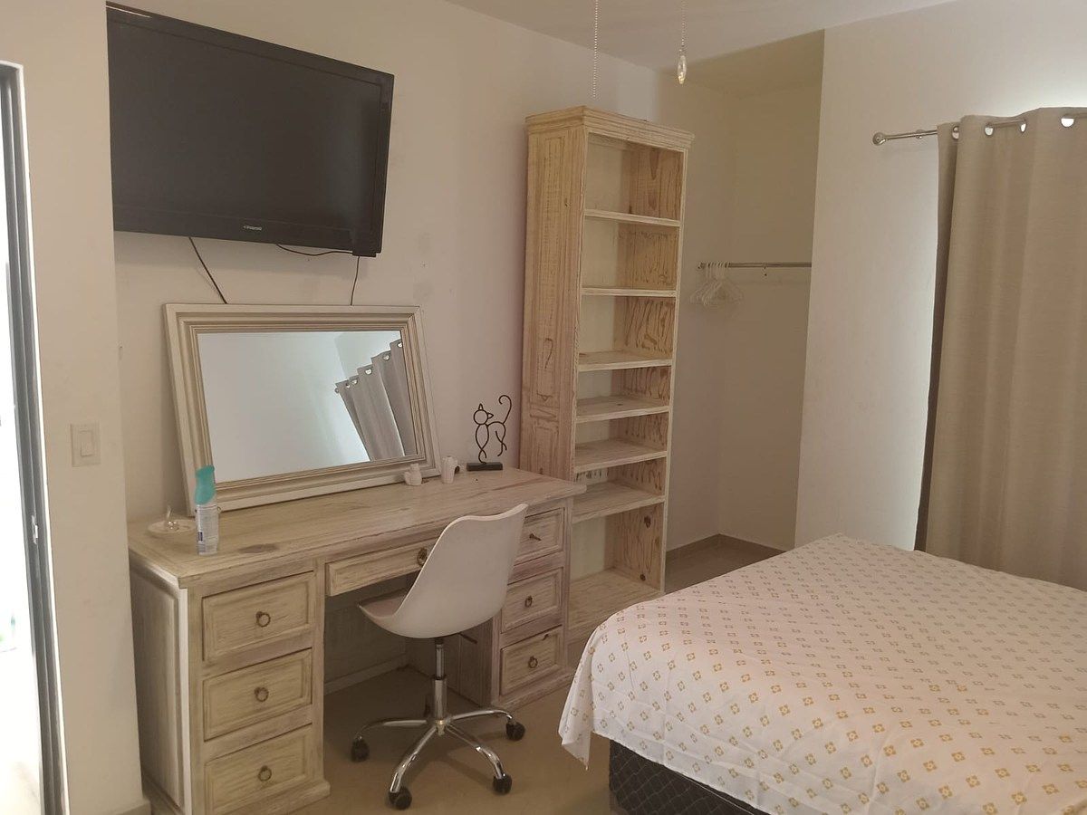 21 de 34: Cómoda con cajones, espejo, televisión y mueble con repisas.