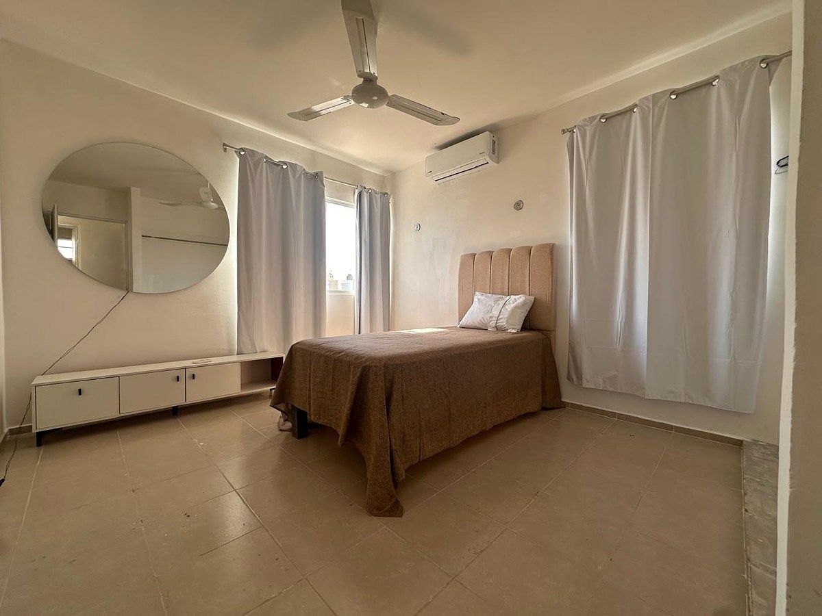 18 de 25: Recámara 2 con cama, aire acondicionado, ventilador y closet