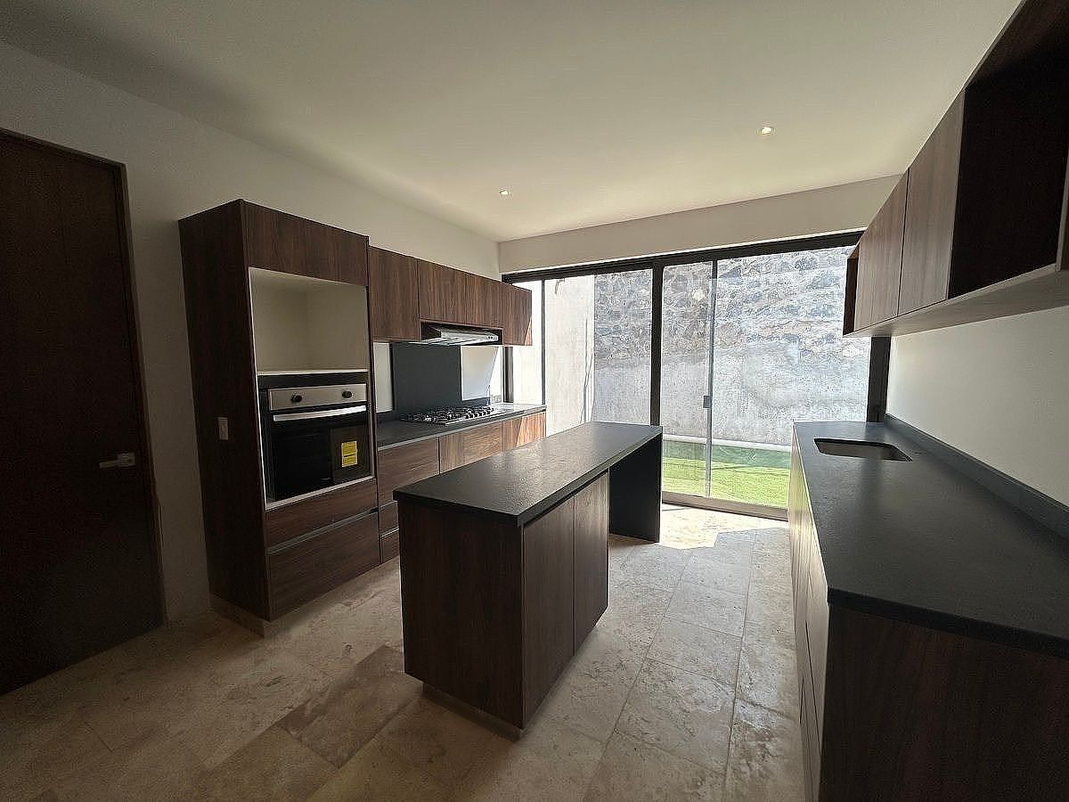 25 de 39: Cocina con barra para Bancos. Vista y acceso al Jardín.