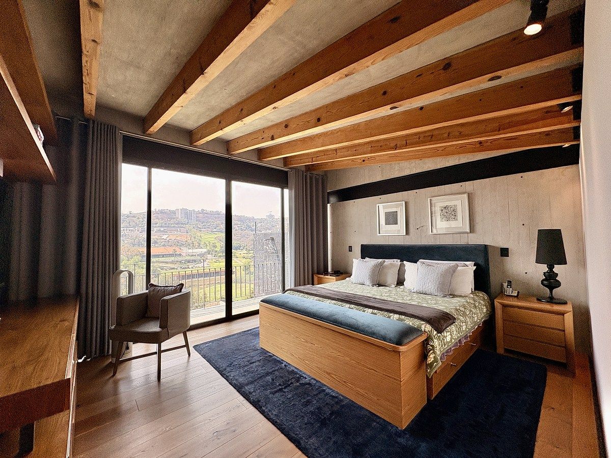 15 of 24: Recámara principal iluminada y techos con detalles en madera