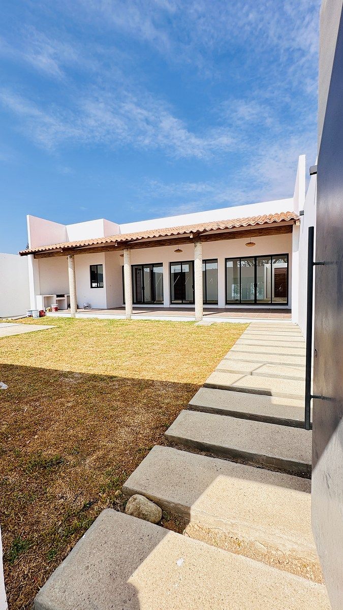 1 of 36: Entrada peatonal, jardín frontal y corredor