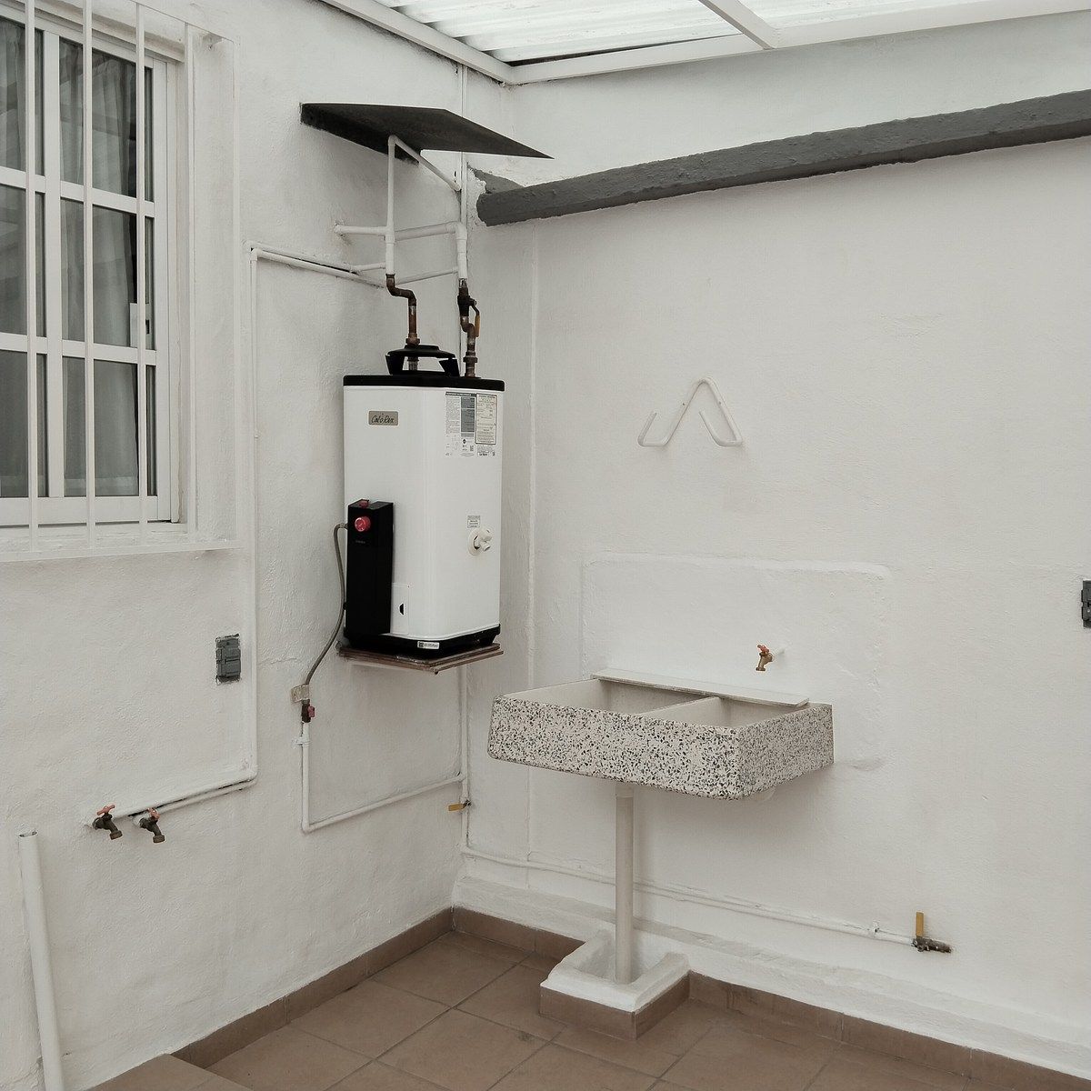 7 of 24: Área de lavado techada. Conexiones para lavadora y secadora