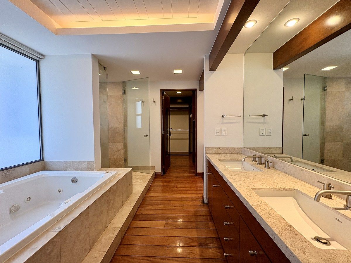 22 de 25: Baño principal con doble lavamanos y piso de madera