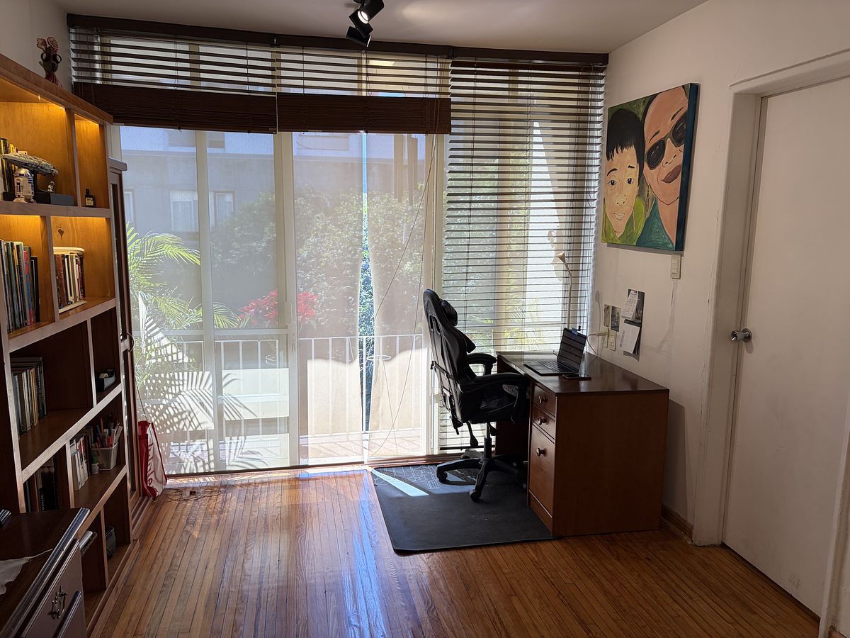 18 de 25: Home office con balcón con persiana