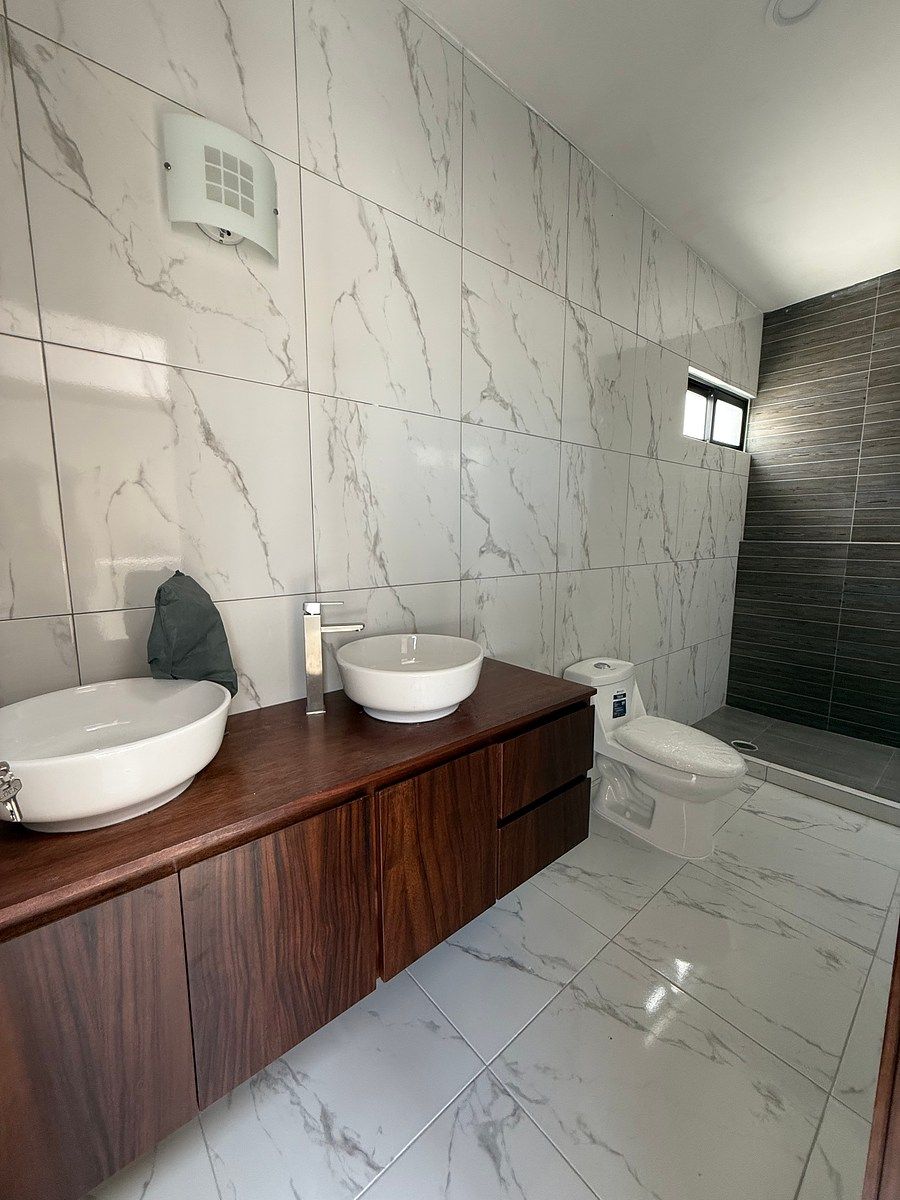 22 de 46: Baño completo con dos lavabos en recámara principal.