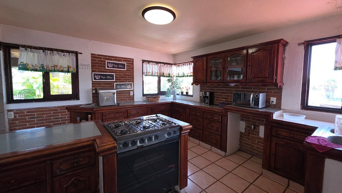 13 de 40: Cocina integral de madera, con desayunador.