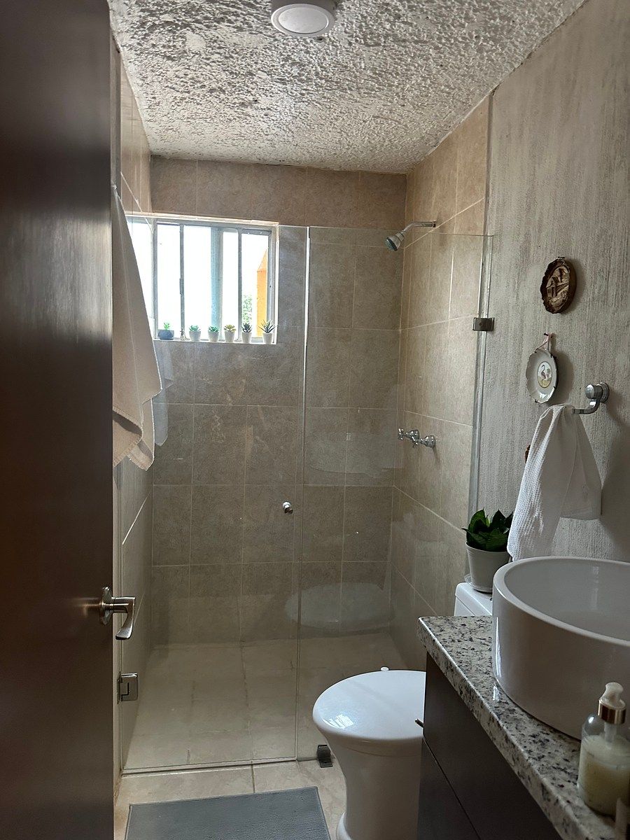 Baño remodelado con cancel de cristal en regadera moderna, foto 9 de 18